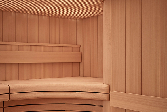 Curved wooden walls and floors of the pink hued sauna
