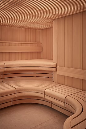 Curved wooden walls and floors of the pink hued sauna